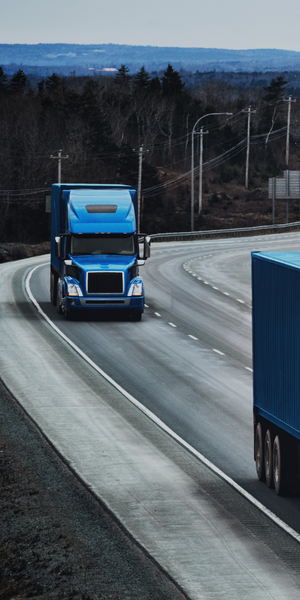 Semi-Truck driving down a highway road.