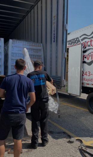 Team assisting in transferring a load into another trailer for a customer.